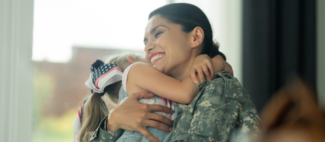 Military mother holding child.