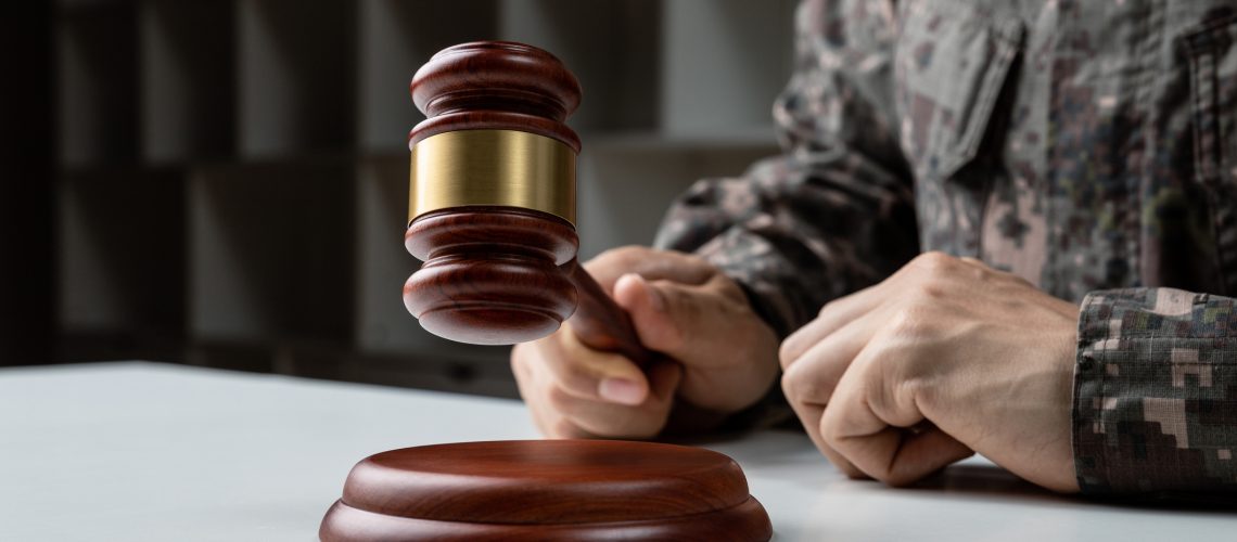 Hand of soldier holding gavel